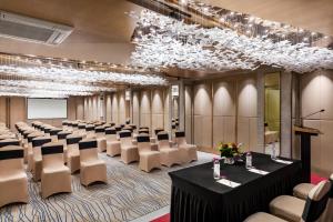 a conference room with rows of tables and chairs at Ramada Encore by Wyndham Siliguri Sevoke Road in Siliguri