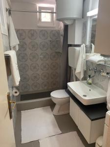 a bathroom with a white toilet and a sink at Villa Volga in Jelsa