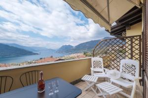 a balcony with a table and chairs and a view of the water at De Gasperi 14 in Sale Marasino