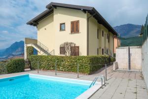 a villa with a swimming pool in front of a house at De Gasperi 14 in Sale Marasino