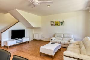 un salon avec deux canapés et une télévision à écran plat dans l'établissement Villa Brenda Torremirona Resort, à Navata