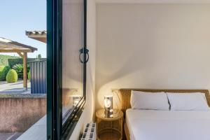 une chambre avec un lit donnant sur un balcon dans l'établissement Villa Brenda Torremirona Resort, à Navata 24 autres photos