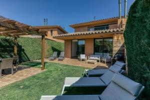 une arrière-cour avec un canapé et des chaises ainsi qu'une maison dans l'établissement Villa Brenda Torremirona Resort, à Navata