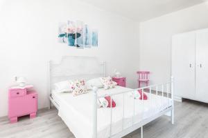 Dormitorio blanco con cama blanca y muebles de color rosa en Holiday Home Shabby en Vela Luka