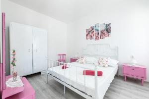 1 dormitorio blanco con cama blanca y muebles de color rosa en Holiday Home Shabby en Vela Luka