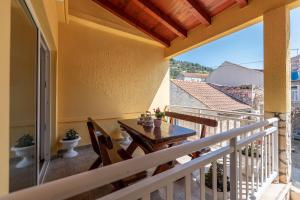 un balcón de una casa con mesa y sillas en Holiday Home Shabby en Vela Luka