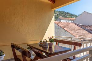 balcón con mesa y sillas de madera en Holiday Home Shabby en Vela Luka