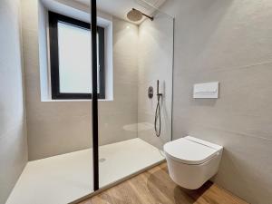 a white bathroom with a shower and a toilet at Casa Indiana Hotel Boutique in Blanes