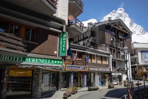 um grupo de edifícios numa rua com uma montanha em Hotel & Ristorante Serenella em Breuil-Cervinia