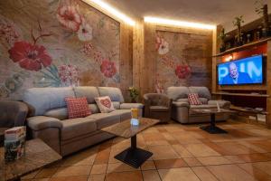 a living room with a couch and a tv at Hotel & Ristorante Serenella in Breuil-Cervinia