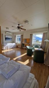 a bedroom with two beds and a living room at Sognefjord Hotel in Hermansverk