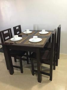 a wooden table with chairs and plates and cups on it at Donadel Hometel in Iloilo City