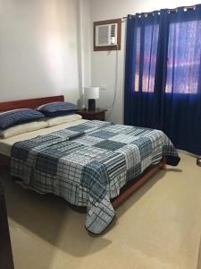 a bedroom with a bed and a blue curtain at Donadel Hometel in Iloilo City