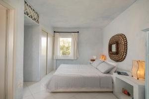 um quarto branco com uma cama e um espelho em Casa Silvana by Wonderful Italy em Porto Cervo