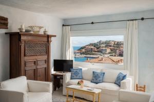 a living room with a white couch and a window at Casa Silvana by Wonderful Italy in Porto Cervo
