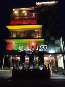 un edificio con un'insegna al neon di fronte di Hotel Simfony Alor a Kalabahi