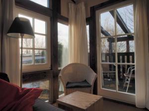 - un salon avec de grandes fenêtres et une table dans l'établissement Auf den Hoefen Fewo 13, à Kühlungsborn