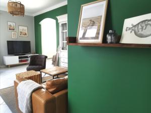 a living room with a couch and a green wall at Homelig Altstadt Ferienwohnung Sassnitz 3 in Sassnitz