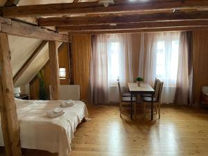 a bedroom with a bed and a table with chairs at Kapteinis in Liepāja