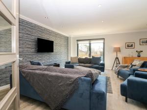 a living room with blue furniture and a brick wall at Woodend Croft in Ellon
