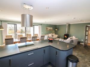 a kitchen with a island in the middle of a living room at Woodend Croft in Ellon