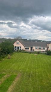 a large grass field in front of a large building at Pinebrook BnB En-suite 1 double bed in Killybegs