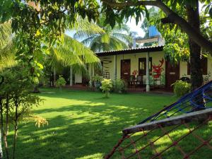una casa con un patio con un columpio en Lobster Inn, en Trincomalee