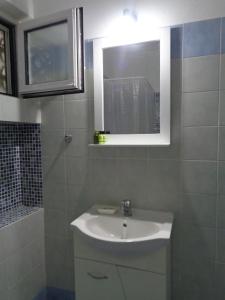 a bathroom with a sink and a mirror and a shower at Porto View Suites and Apartments in Porto Heli