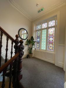 a hallway with a staircase and stained glass windows at Deluxe Huge Detached House with Parking, sleeps up to 30 people, 2m from Liverpool City Centre in Liverpool