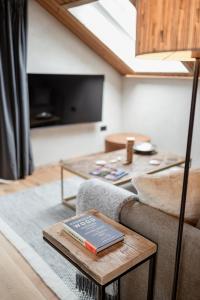 een woonkamer met een bank en een tafel met een boek bij Osprey Lodge in Aviemore