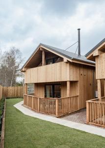 een houten gebouw met een hek ervoor bij Osprey Lodge in Aviemore