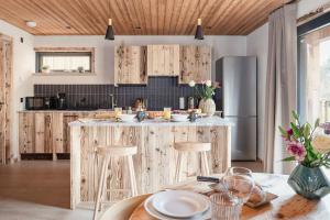 een keuken met houten kasten en een tafel met stoelen bij Osprey Lodge in Aviemore