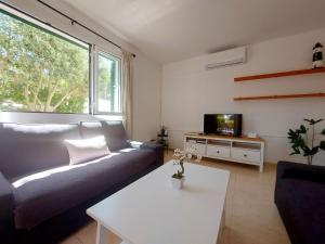 a living room with a couch and a tv at Villa Limón in Cala Blanca