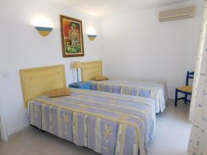 une chambre avec deux lits et un tableau au mur dans l'établissement Estrela Mar Marina Villa, à Quarteira 33 autres photos