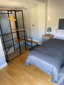 a bedroom with a bed and a desk and a shelf at VUT Dúplex Miraluz in Cuenca