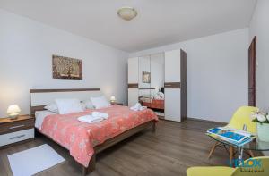 een slaapkamer met een bed, een bureau en een stoel bij Darko in Poreč
