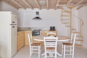een keuken met een tafel en stoelen en een wenteltrap bij Town Mansion by Monocle in Mykonos-stad +14 foto's
