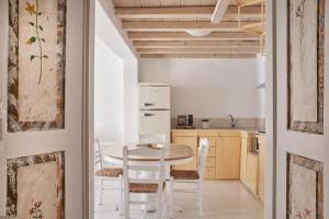 een keuken met een witte tafel en stoelen bij Town Mansion in Mykonos-stad