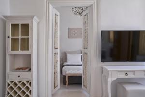 een witte kamer met een tv en een slaapkamer bij Town Mansion in Mykonos-stad