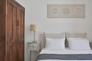 een slaapkamer met een bed met witte kussens bij Town Mansion in Mykonos-stad