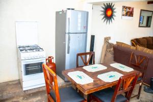a kitchen with a table and a refrigerator at Stone Camp Naivasha in Naivasha