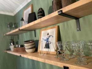 a shelf with wine glasses and a picture on it at Homelig Altstadt Ferienwohnung Sassnitz 3 in Sassnitz