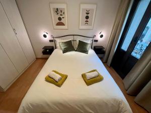 a bedroom with a white bed with two towels on it at Bcn Friendly Parlament in Barcelona
