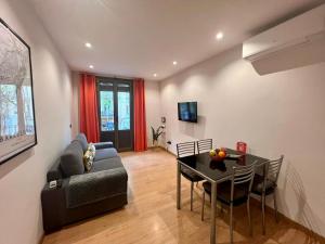 a living room with a couch and a dining room table at Bcn Friendly Parlament in Barcelona