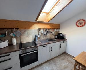 una cocina con fregadero y estufa en Ferienwohnung Gruberhof, en Rimsting 25 fotos más