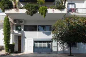 a white building with a blue garage at Architect Art Studio in Athens