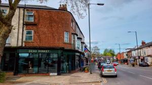 a street with a car parked in front of a building at To de-List in Heeley