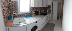 a kitchen with a sink and a washing machine at Sweet flat in Tortosa in Tortosa