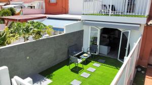 een balkon met een zwembad en gras bij New Garden Solarium Bungalow in Maspalomas