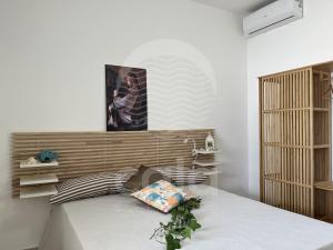 ein Schlafzimmer mit einem Bett mit hölzernem Kopfteil in der Unterkunft Villetta Carmine By Cala Salento in Torre Lapillo